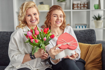 Happy mother and daughter with presents at home