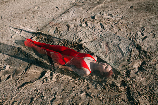 Young woman lying in glass coffin