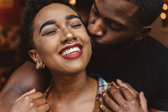 Close up portrait of young black couple hugging