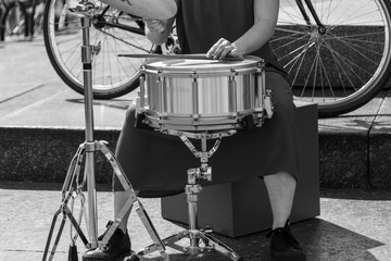 Female hands playing the drum in an urban environment. Black and white picture