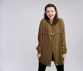 A portrait above the knee of a pretty adult brunette girl in a dress on a white background. Standing directly in front of the camera, showing different poses and emotions.