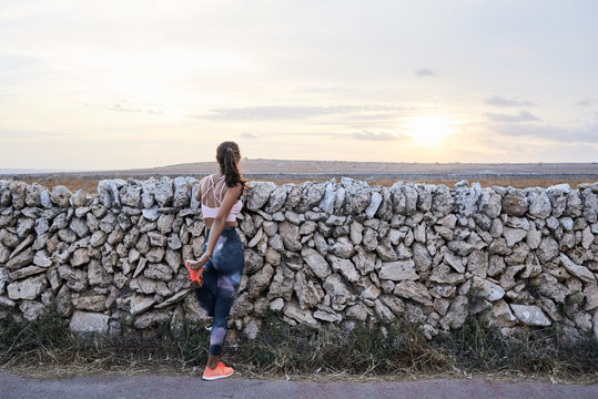 Athlete stretching legs in countryside.