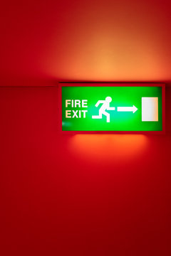 Fire exit sign on a red wall