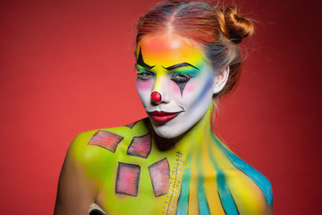 Fototapeta premium Lovely young lady with a face painting clown.