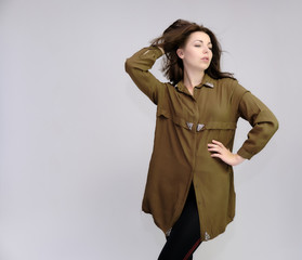 A portrait above the knee of a pretty adult brunette girl in a dress on a white background. Standing directly in front of the camera, showing different poses and emotions.