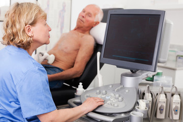 Obraz premium doctor examines a senior man with ultrasonic device