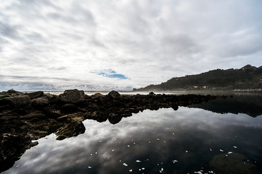 Clouds over water and stones on island
