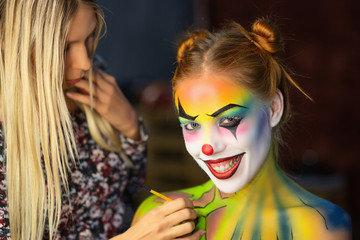 Obraz premium Makeup artis puts a aqua makeup on a attractive lady.