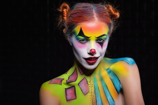 Playful lady with a face painting clown.