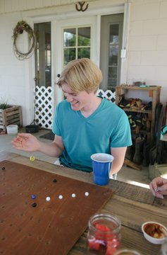 teenage friends play board game outside on patio