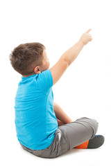 Adorable little boy pointng at wall. Isolated on white background 
