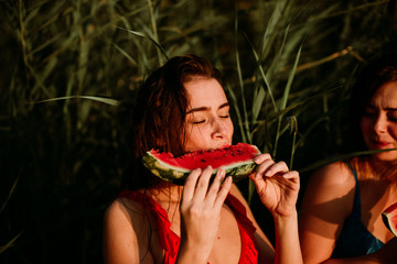 A woman eats a watermelon