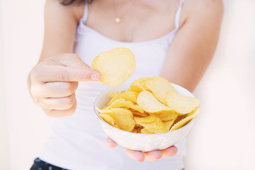 A girl holding the big potato chips bowl. Asking to eating together, Happiness sharing concept. White background.