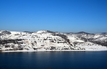 A lake near a hill covered with snow