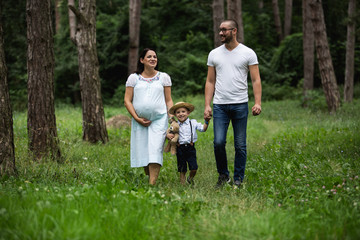 Fototapeta premium Pregnant young woman with her family in nature