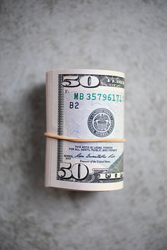 Rolled up $50 USA dollar bills on grey background