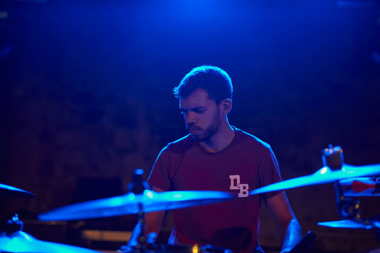 Young drummer with blue light