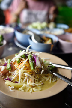 Plate of Thai nam ya topped with fresh vegetables at a street restaurant