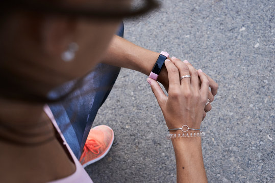 Female runner checking smartwatch app during workout.