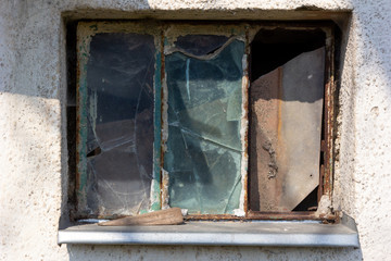 A rusty window with broken glass panes