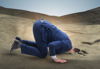 Businessman hiding his head in sand escaping from problems