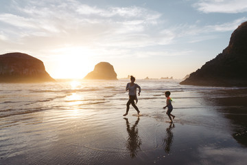 Obraz premium Mother and son enjoying beach during sunset