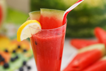 Glass of watermelon juice with lemon and straw. Healthy summer refreshment in hot days.