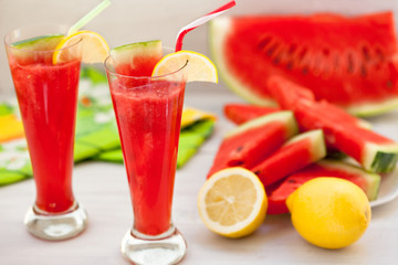 Two glasses of watermelon juice with lemon and straw. Healthy summer refreshment in hot days.