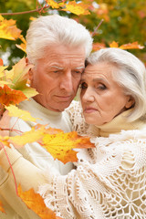 Portrait of sad senior couple in autumn park