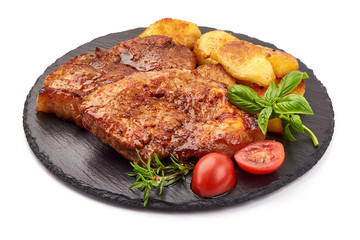 Baked juicy pork steak with fried potatoes on a stone plate, isolated on white background