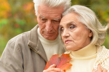 Portrait of sad senior couple in autumn park