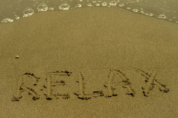 Word Relax written at sandy beach