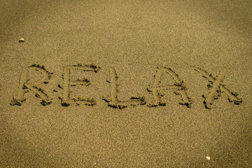 Word Relax written on the sand