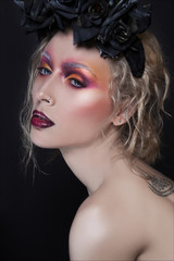 Creative fashion and beauty close-up portrait with black roses. Creative make up on young pretty woman