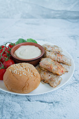 Spring roll with meat and vegetables served on a white dish with sauce. Light background under the concrete.