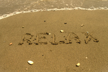 Word Relax written at sandy beach