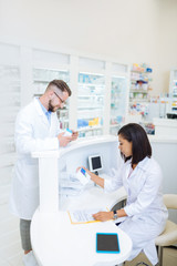 Concentrated brunette girl reading composition of pills