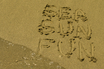 Words Sea, Sun, Fun written at sandy beach