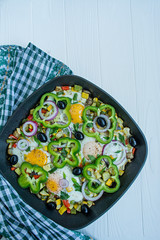 Fried eggs with vegetables in a pan. Shakshuk. Arabic cuisine Proper nutrition. View from above. Space for text.