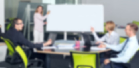 Blurred people. Business woman holds a presentation in the office. Manager speaks to employees. Tell the plan of the new project.