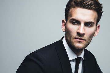 Portrait of young and handsome model in a classic black and white style clothing. Studio shot. Copy...