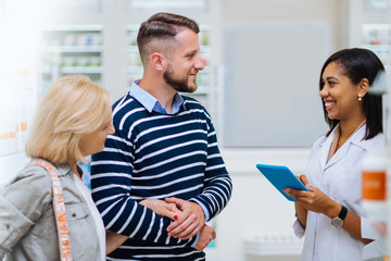 Kind brunette man consulting with pretty pharmacist