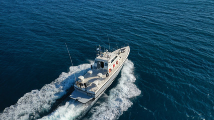 Fototapeta na wymiar Aerial drone photo of small powerboat cruising in high speed in deep blue Mediterranean sea