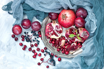 Group of fresh summer fruits -  pomegranates  with green leaves