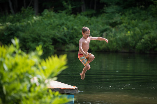 Timeless Summer Fun Child Jumping From Dock Into Pond 