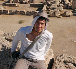 Young man wearing a hat on an old Roman ruin in Baalbek