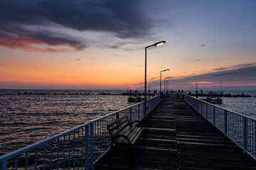 Walkway over sea with light poles at sunrise with amazing colors