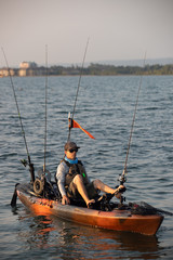 Fototapeta premium Young Man Kayak Fishing at Sunrise in Canada