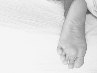 One mam foot on the bed, black and white