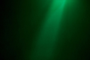 A light green ray of light falls on a dark green textural background